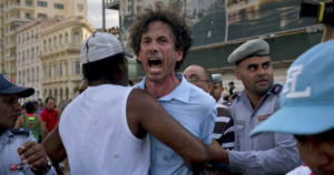 En la foto, policías y policías de civil defetienen a un hombre que protesta