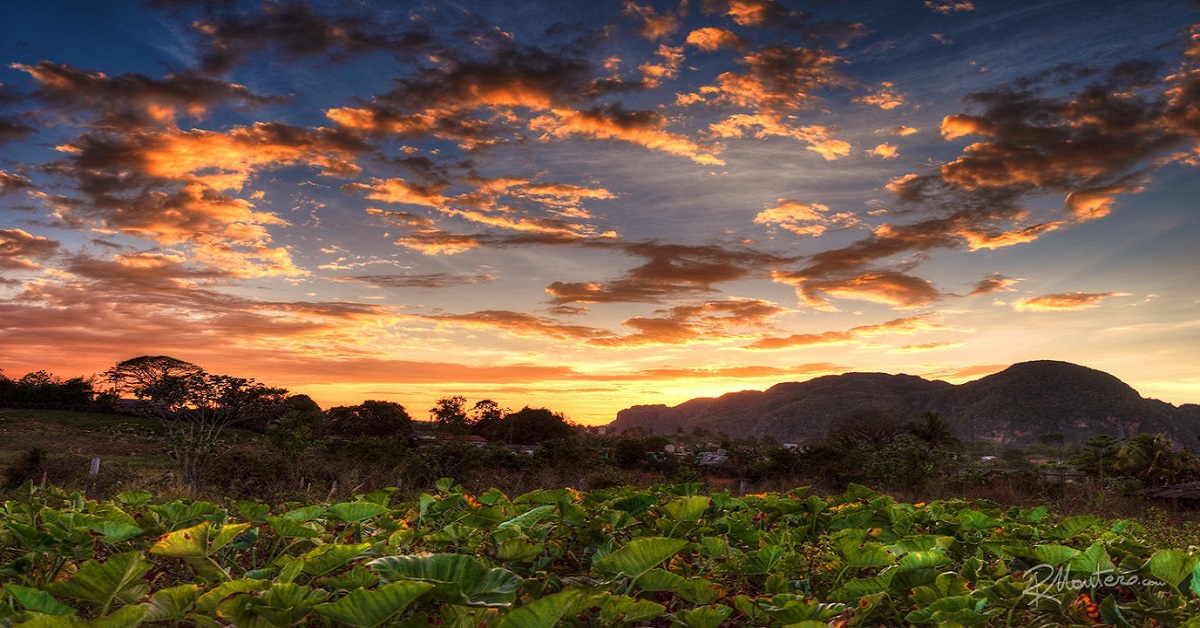 En la foto se ve una puesta de sol detrás de unas lomas en algún lugar de Cuba