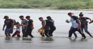 En la foto se ven personas cruzando la frontera sur de EEUU por el río Bravo