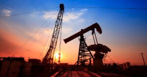 En la foto se ve un pozo de petróleo al amanecer