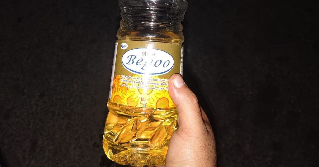 En la foto, un pomo de aceite en la mano de una persona