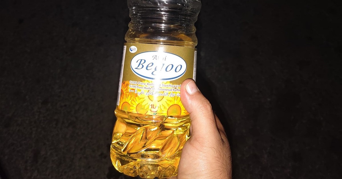 En la foto, un pomo de aceite en la mano de una persona
