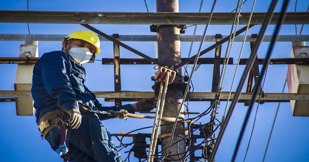 En la foto, un trabajador eléctrico sobre una torre, en algún lugar de Matanzas