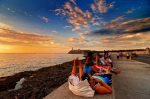 En la foto, jóvenes en el malecón de La Habana al amanecer