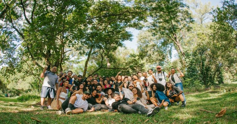 En al foto, un grupo de jóvenes reunidos bajo unos árboles