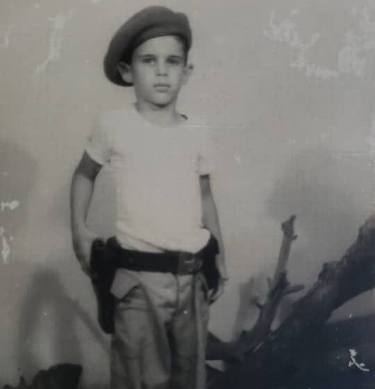 En la foto, un niño vestido de miliciano con una pistola a la cintura