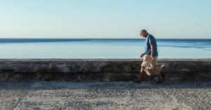 En la foto, un vendedor ambulqante camina cabzbjo por el Malecón