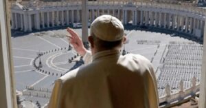En la foto, el Papa asomado a un balcón mira a la Plaza de San Pedro