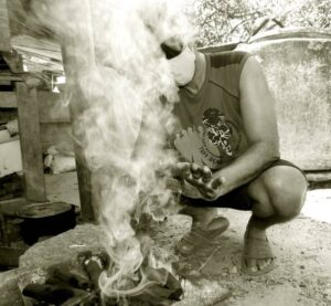 En la foto, un homo blanco sale de unos leños encendidos
