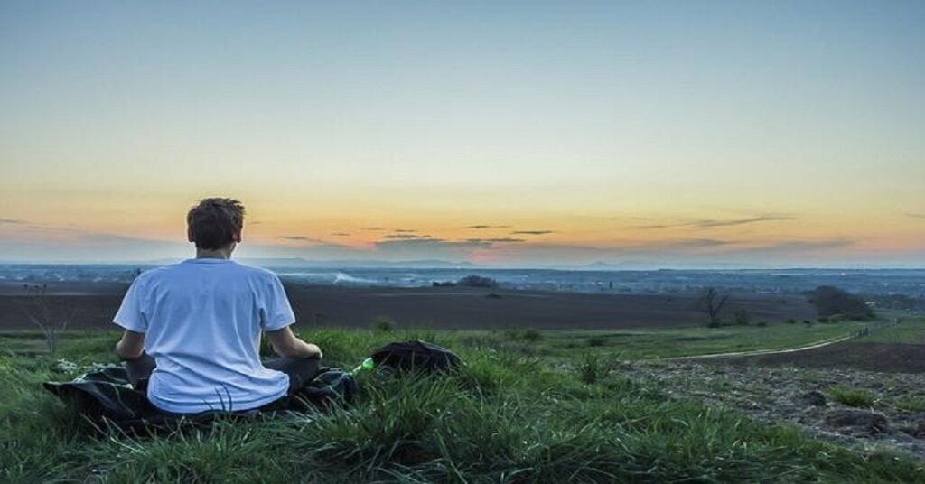 En la foto, un hombre sentado mira al horizonte