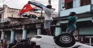 En la foto, cubanos parados sobre un auto policial volcado