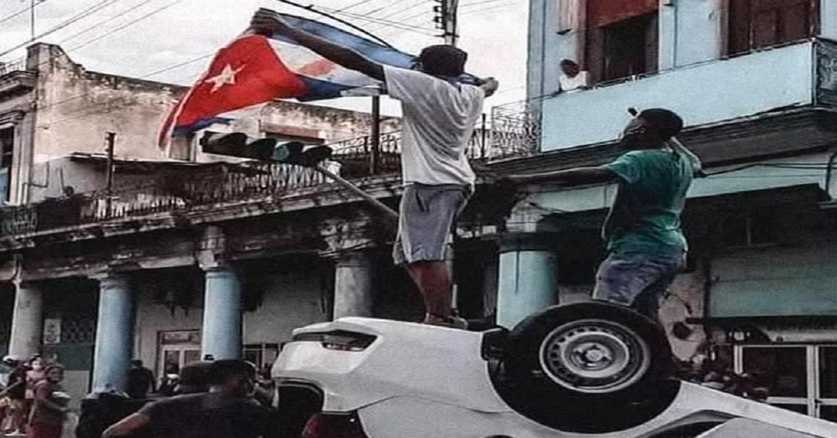 En la foto, cubanos parados sobre un auto policial volcado