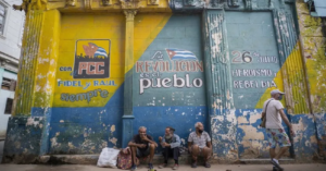 En la foto, cubanos en extrema pobreza frente a carteles 'revolucionarios'