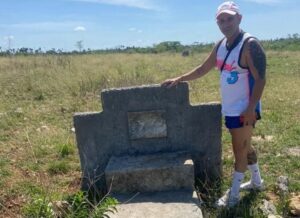 En la foto, el autor al aldo de la tarja que recuerda al piloto muerto