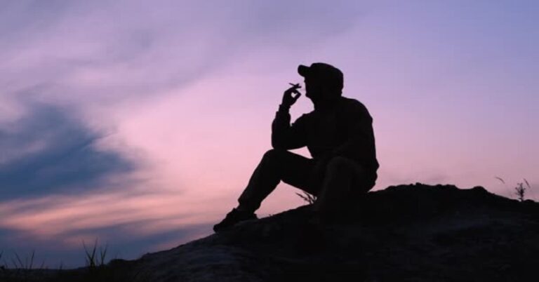 En la foto, un hombre fuma al amanecer
