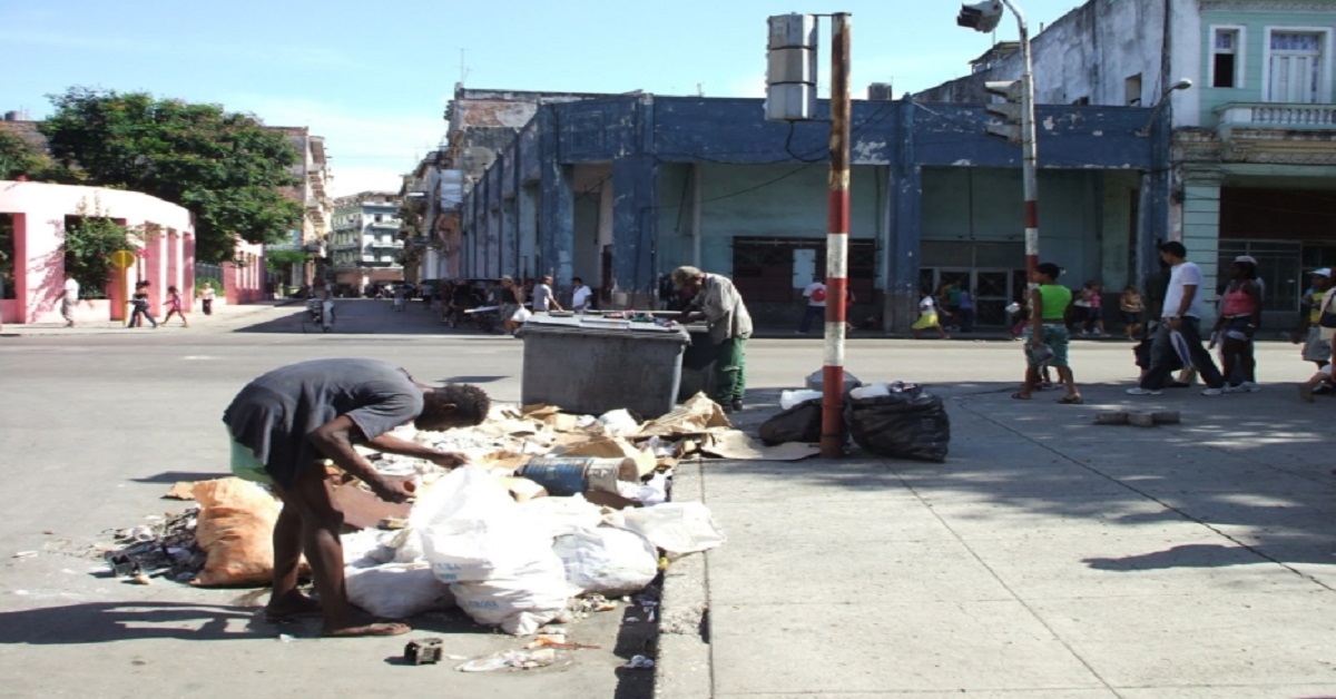 En la foto, personas buscan comida en la basura en La Habana