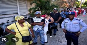 Una cola enorme en Cuba, custodiada por un policía