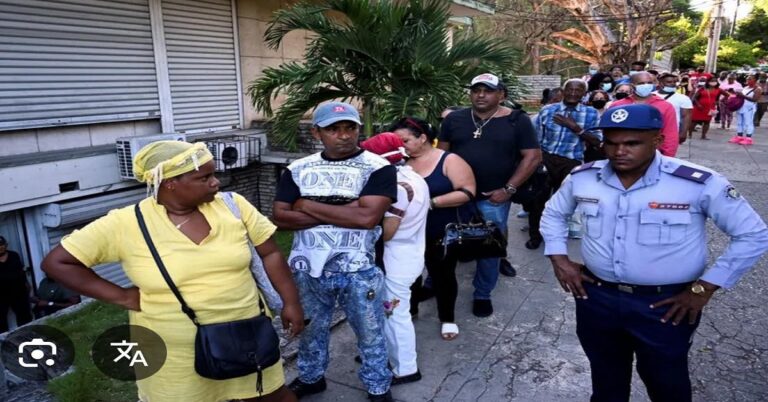 Una cola enorme en Cuba, custodiada por un policía