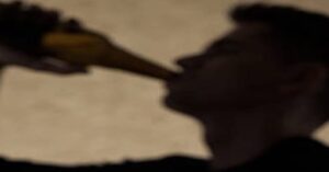 En la foto, una imagen difusa de un hombre bebiendo