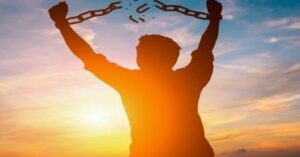 En la foto, un hombre rompe las cadenas que lo aprisionan