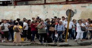 En al foto, decenas de personas esperan un transporte en La Habana