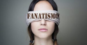 En la foto, una mujer tiene sus ojos tapados con pañuelo donde se lle la palabra fanatismo