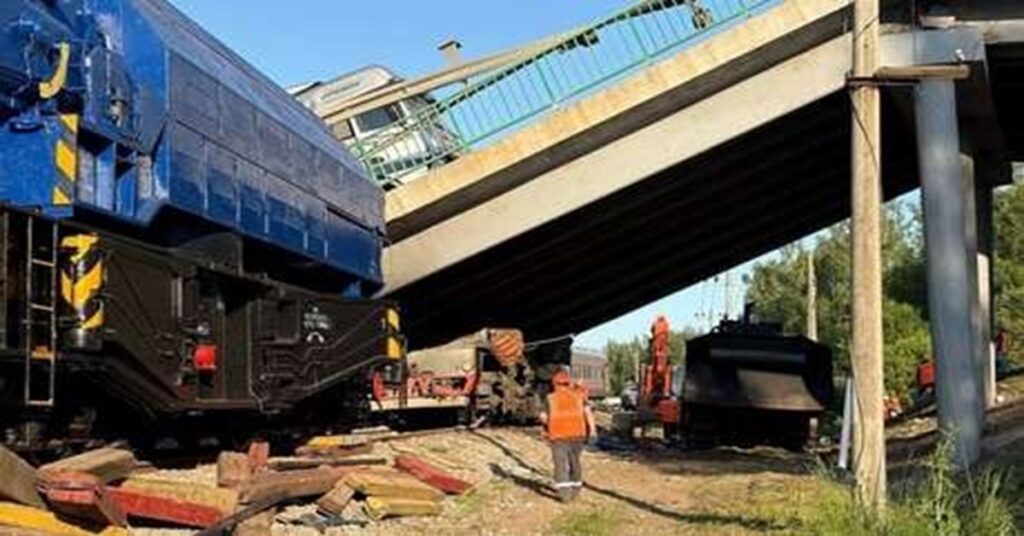 En la foto, un puente volado cae sobre un tren en Rusia