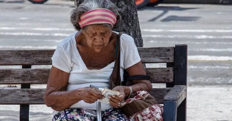 En la foto, una anciana cubana cuenta dinero