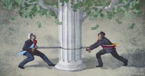 En la foto, un cubano y un venezolano serruchan una columna de cemento