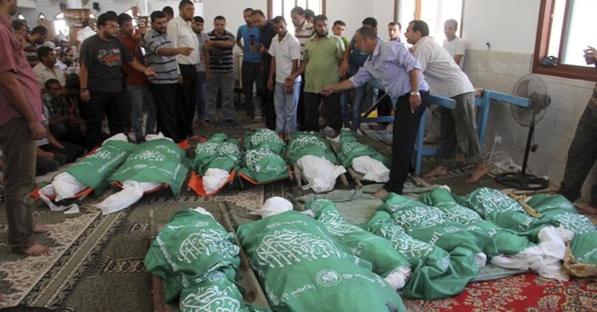 En la foto, hombres delante de varios cadáveres de gazatíes