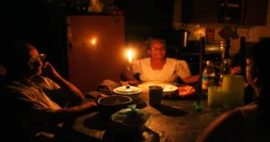 En la foto, una familia cubana cena sin electricidad