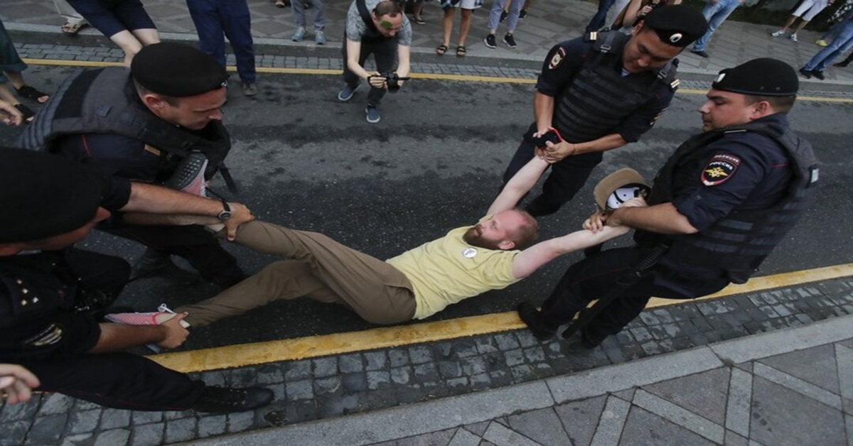 En la foto, policías rusos detienen a inmigrantes