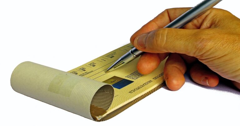 En la foto, un hombre firma un cheque