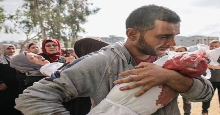 En la foto, un hombre sostiene a un niño herido, o muerto, en Gaza