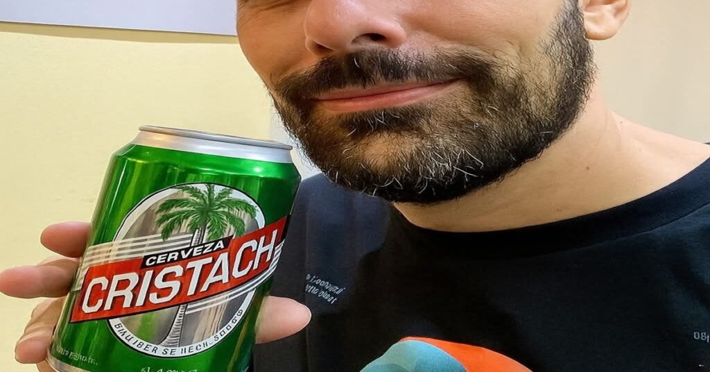 En la foto, el rostro de un hombre con una cerveza Cristal en la mano