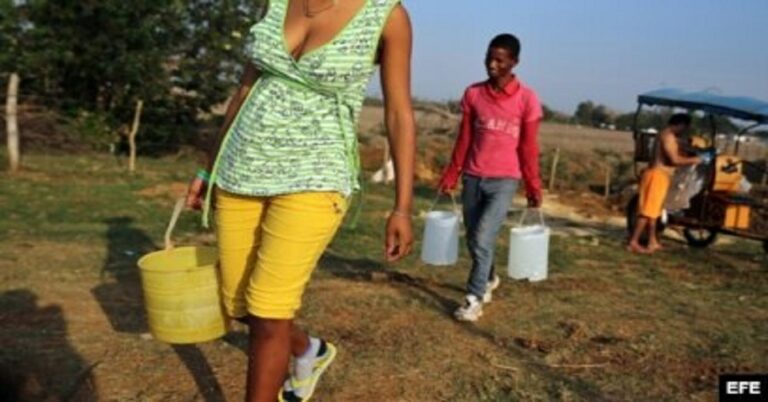 En la foto, personas cargando agua en Cuba