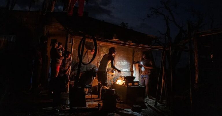 En la foto, cubanos cocinan en apagón