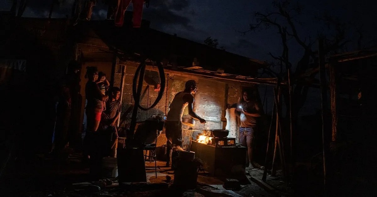 En la foto, cubanos cocinan en apagón