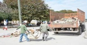 En la foto, hombres recogen basura y escombros en Sancti Spíritus