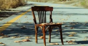 En la foto, una silla abandonada en una carretera abandonada