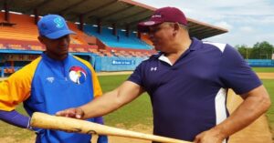 En la foto, Eriel Sánchez muestra un bate a un jugador