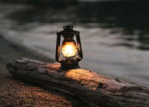 En la foto, un farol sobre un tronco en el piso