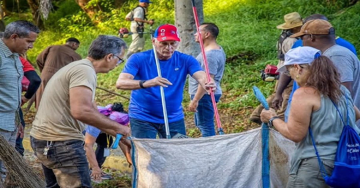 En la foto, Díaz-Canel intenta ser empático y recoge basura en La Habana