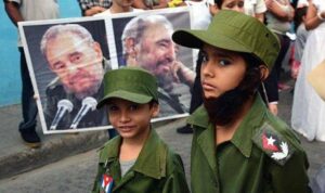En la foto, niños vestidos de militares delante de fotos de Fidel Castro