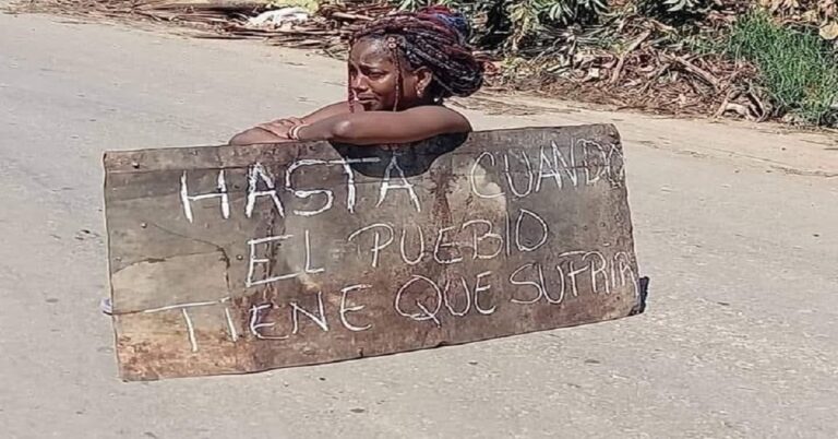 En la foto, una mujer cubana, con un letrero en un latón, se pregunta hasta cuándo