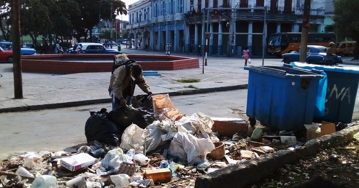 En la foto, un hombre busca comida en la basura en Cuba