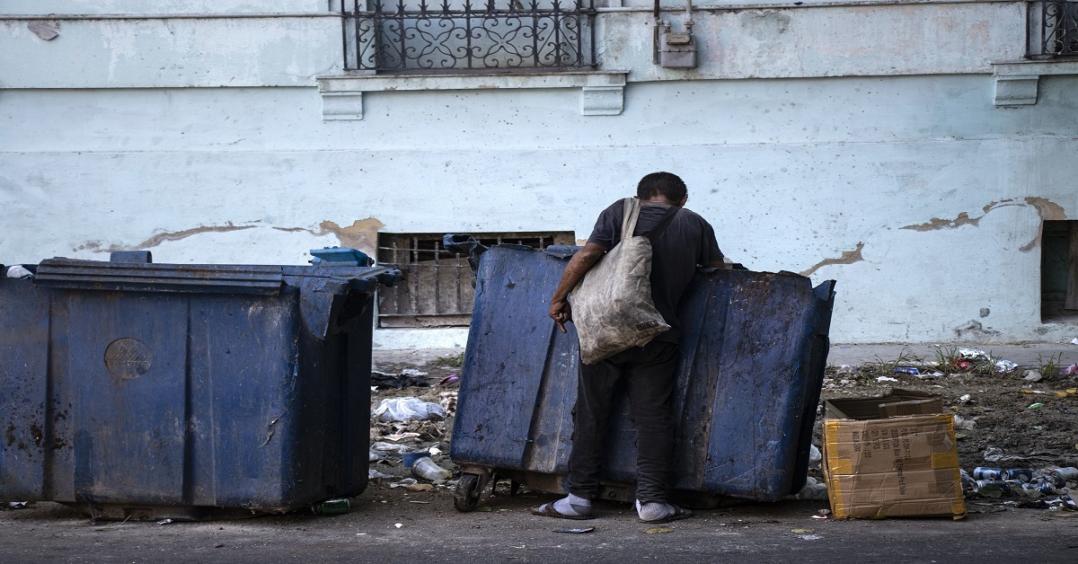 En la foto, un hombre busca alimentos en la basura en Cuba
