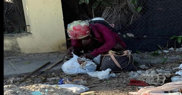 En la foto, una mujer cubana husmea en la basura