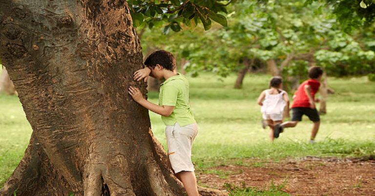 En la foto, niños jugando a los escondidos