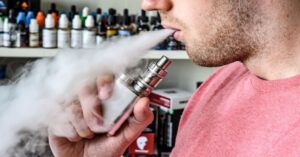 En la foto, un joven vapeando